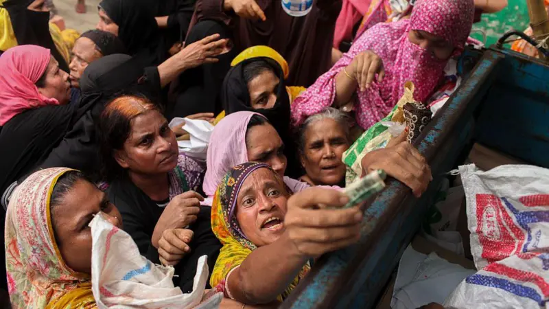 ঢাকায় টিসিবি'র ট্রাক থেকে পণ্য কিনতে লাইনে দাঁড়িয়ে আছেন অনেকে